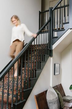 a woman is walking down the stairs in her home