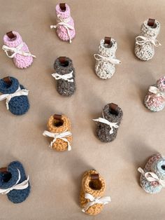 there are many crocheted baby booties on the table with ribbons around them