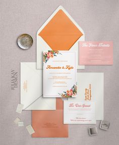 the wedding stationery is laid out on top of each other, including an orange and white envelope