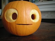 a carved pumpkin with eyes and nose on a table