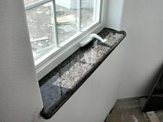 a window sill in front of a white wall