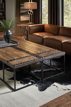 a living room with leather couches and a wooden coffee table in the center area