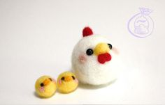 two small yellow chicks sitting next to each other on a white surface with an egg in the background