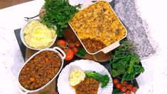 several dishes of food are arranged on a table