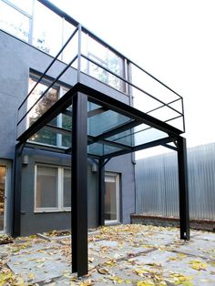 an empty building with a metal frame and glass balconies on the top floor