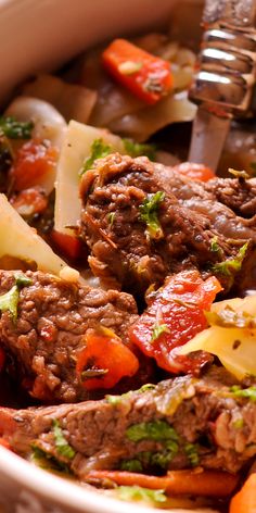 a bowl filled with meat and vegetables on top of a table