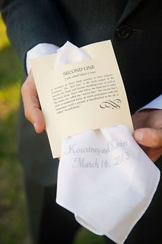 a person in a suit holding a piece of paper with the words second line written on it