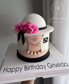 a birthday cake with a woman's hat on top