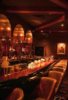 a dimly lit bar with chairs and lights