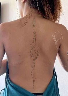 the back of a woman's body with tattoos on her upper and lower back