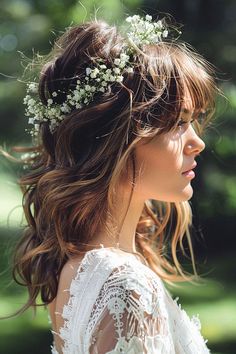 a woman with flowers in her hair wearing a white lace dress and floral headpiece