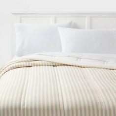 a bed with white and brown striped sheets