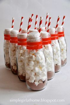 six mason jars filled with marshmallows and candy canes