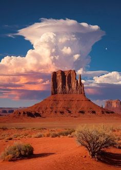 the desert is full of red sand and tall rock formations with clouds in the sky