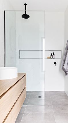 a bathroom with white walls and wooden cabinets