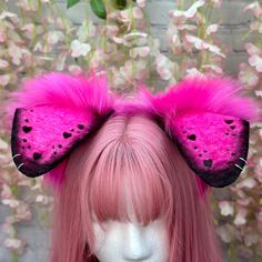 a close up of a wig with pink hair and two ears on top of it