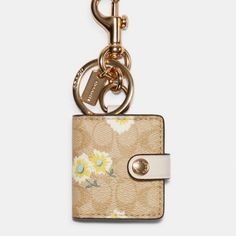 a keychain with a flower print on it and a metal hook attached to it