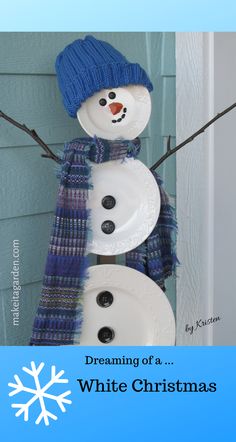 a snowman made out of paper plates with a blue hat and scarf