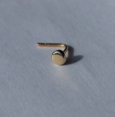 "14K Gold Flat Nose Stud. Gold Nose Stud - I make these in 4 styles- L, Nose Bone, Earring Straight stud or Screw in 18,20 or 22 gauge. 18 is thicker, 20 is standard earring thickness and 22 is thinner. The \"Dot/Disc\" is flattened and has a shiny finish. Material - 14K yellow, Rose or White gold. Rose gold will have yellow gold stem with Rose gold dot (flattened ball). Request taken- Contact me for other sizes Disc (flattened Ball) is 3mm diameter, each uniquely hand made for you. Looks a litt Bone Nose Stud, Classic Round Internally Threaded Nose Studs, Minimalist Round Nose Studs, 1.5 Mm Nose Stud, Nickel-free Round Nose Studs As Gifts, Silver Nose Stud, Tiny Nose, Flat Piercing, Nose Bone