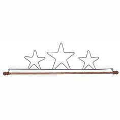 three metal stars hanging on a wall next to a wooden pole with an iron rod