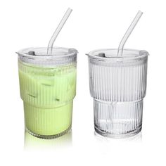 two cups with straws in them sitting next to each other on a white surface