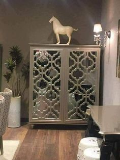 a horse statue on top of a cabinet in a living room