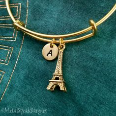 "This listing is for an Eiffel tower bangle bracelet. This bracelet is adjustable, which makes it a great gift for someone if you don't know their wrist size. Just squeeze to adjust! :) One size fits most. You'll be able to choose your initial from the drop-down menu, and you can also choose to have these charms placed on a keychain or necklace instead. **Please see the second photo for charm scale. These are SMALL charms. The initial charm measures 3/8\". If you want a different quantity than you see listed here, just write and ask!  **Please note that this is gold-tone and not actually made from real gold. ITEM CARE: We recommend our items never come into contact with moisture, for best results. - - - - - - - Sign up for our newsletter to receive coupons and updates on new items! Follow French Bracelet, Paris Charm Bracelet, Bracelet Initial, French Jewelry, Small Charms, Bridesmaid Bracelet, Letter Charms, Personalized Initials, Initial Charm