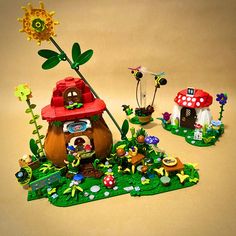 a group of toys that are sitting on the ground in front of some plants and mushrooms