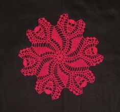 a red doily on a black background