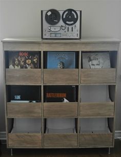 a record player sitting on top of a wooden shelf filled with vinyl records and cds