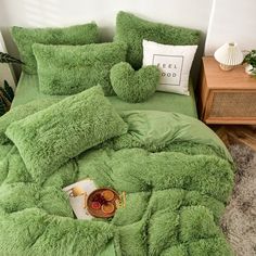 a green comforter and pillows on a bed