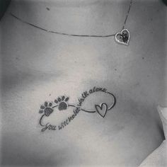 a woman's chest with a dog paw and heart tattoo on the left side