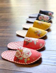 several pieces of fabric are lined up on a wooden floor, one is red and the other is yellow