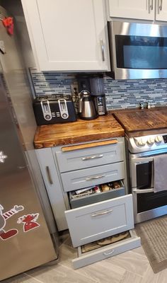 a kitchen with stainless steel appliances and wooden counter tops, including a stove top oven