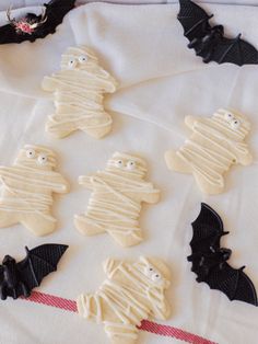 halloween cookies decorated with icing and bats on a white cloth, ready to be eaten