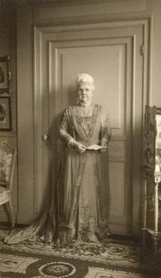 an old photo of a woman standing in front of a door