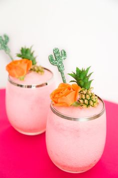 two glasses filled with pink liquid and topped with succulents