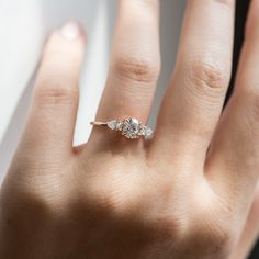 a woman's hand with a diamond ring on it