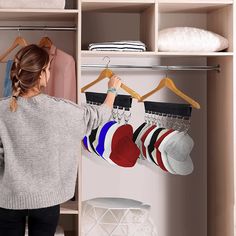 a woman is looking at socks hanging on a rack in the closet with other clothes