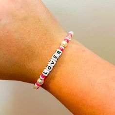 Adorned with dainty beads and a charming word that celebrates your favorite era, this bracelet is a perfect nod to Taylor’s iconic style and empowering lyrics. Lover Bracelet, Swimsuit Jewelry, Lovers Bracelet, Jeweled Earrings, Taylor S, Iconic Style, Pink Bracelet, Wide Brimmed Hats, Sunglasses Shop