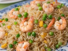 shrimp and rice with peas on a blue and white plate, ready to be eaten