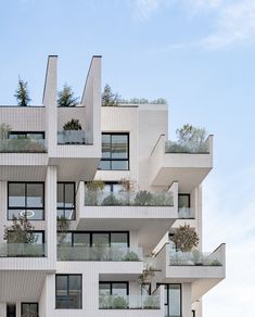 an apartment building with many balconies and plants growing on the balconies