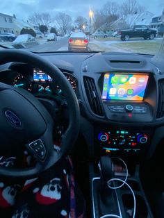 the interior of a car with an electronic screen and steering wheel controls in front of it