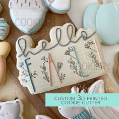 cookie cutters and decorated cookies on a table with the words hello written in cursive