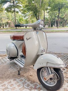 an old scooter is parked on the side of the road