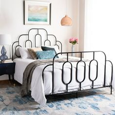 a bedroom with a metal bed frame and blue rug