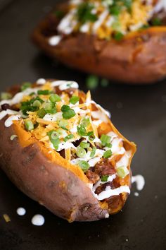 two loaded sweet potatoes with green onions and cheese