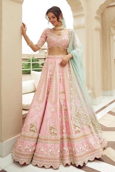 Pastel pink embroidered lehenga with elephant and bird motif embroidery in cutdana, pearl and tikki and attached cancan. Paired with a padded floral embroidered blouse with tasseled hem and sleeves, and two pastel blue embroidered dupattas. Components: 4 Pattern: Embroidered Type Of Work: Cutdana, Pearl, Tikki Neckline: V Neck Sleeve Type: Elbow Fabric: Silk, Organza Color: Pink Other Details:  Attached lining Padded blouse Approx. product weight: 5 kgs Lehenga length: 44 inches Occasion: Bride, Annus Creation, Raw Silk Lehenga, Resham Embroidery, Silk Crop Top, Pink Lehenga, Embroidered Lehenga, Normal Clothes, Bird Motif, Silk Lehenga