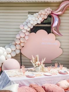 a table set up with balloons and decorations