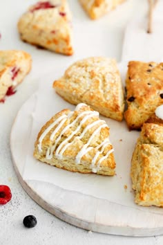 scones with white icing on a plate next to berries and cranberries